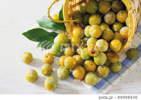 Berries yellow plums on a white wooden table 89998936