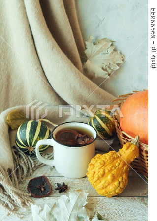 Cup of tea, dry fruits, cashmere plaid, pumpkins and autumn leaves in a basket of leaves, on a wooden table, home comfort concept, Thanksgiving Cup of tea, dry fruits, cashmere plaid, pumpkins and autumn leaves in a basket of leaves, on a wooden table, home comfort concept, Thanksgiving 89999844