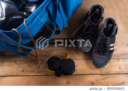 Old boxing shoes and sports bag. Boxing shoes and boxing bandages. View from above. Old boxing shoes and sports bag. Boxing shoes and boxing bandages. View from above. 90000661