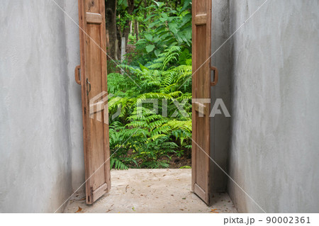 Wooden door open way to natural green plant Wooden door open way to natural green plant 90002361