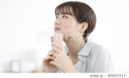 スマートフォンを持って考え事をする若い女性 スマホ スマートフォンを持って考え事をする若い女性 スマホ 90003317