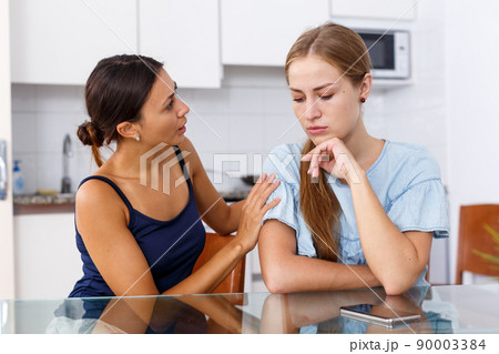 Upset young women discussing, quarrel at home kitchen indoor Upset young women discussing, quarrel at home kitchen indoor 90003384