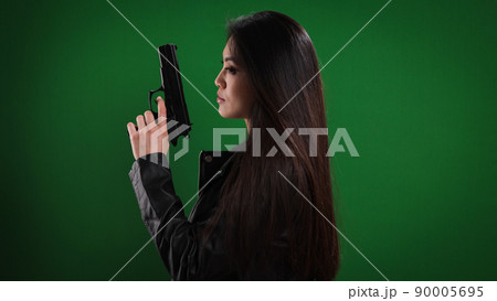 Young female agent with a gun in her hand Young female agent with a gun in her hand 90005695
