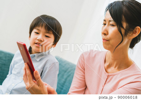 スマホを操作する50代女性と孫 スマホを操作する50代女性と孫 90006018