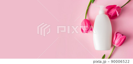Spa skin care products on a pink background. Natural cosmetics and red tulips. Spa skin care products on a pink background. Natural cosmetics and red tulips. 90006522