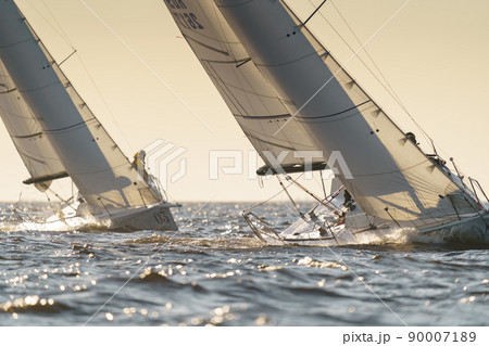 Teamwork in sailing regatta at sunset, still water, the clear sky, hot racing 90007189