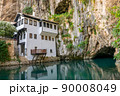 A clean underground river emerges from a cave near an Islamic mosque. 90008049