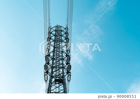 見上げる送電鉄塔の上部と高圧線と雲が少ない青空 ライトカラー 見上げる送電鉄塔の上部と高圧線と雲が少ない青空 ライトカラー 90008551