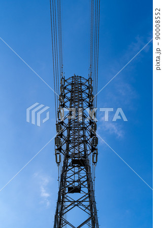 見上げる送電鉄塔の上部と高圧線と雲が少ない青空 タテ 見上げる送電鉄塔の上部と高圧線と雲が少ない青空 タテ 90008552