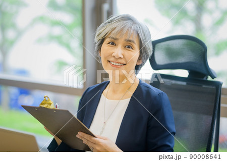 オフィスでデスクワークするシニア ビジネスウーマン 90008641