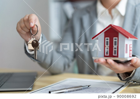 Insurance concept the real estate representative holding a house key on the right hand and the house model on the left hand 90008692