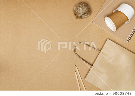 Eco friendly concept, Paper bag with cup and notebook pencil with jute rope on wooden background Eco friendly concept, Paper bag with cup and notebook pencil with jute rope on wooden background 90008748
