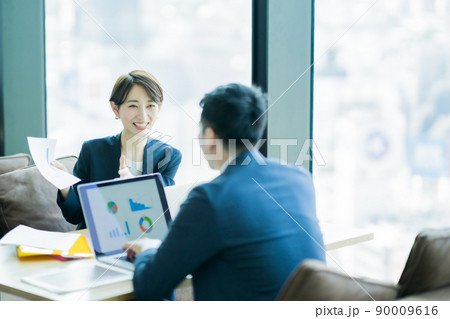 見晴らしの良いオフィスでミーティングをするの男女 見晴らしの良いオフィスでミーティングをするの男女 90009616