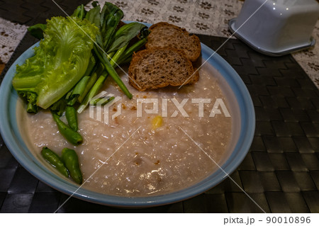 Asian breakfast : Congee, soft boiled rice with ginkgo and vegetables, chilli, Oblique view from the top. Asian breakfast : Congee, soft boiled rice with ginkgo and vegetables, chilli, Oblique view from the top. 90010896