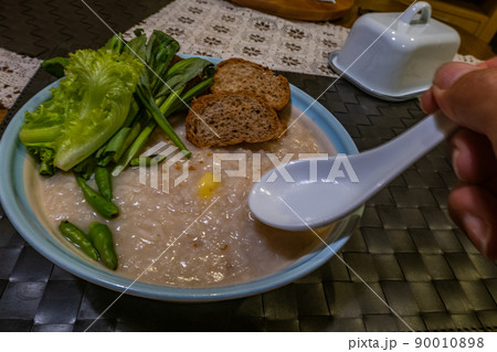 Congee, soft boiled rice with ginkgo and vegetables, chilli, Oblique view from the top. Congee, soft boiled rice with ginkgo and vegetables, chilli, Oblique view from the top. 90010898