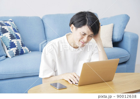 リビングでノートパソコンの前で困る男性 リビングでノートパソコンの前で困る男性 90012638