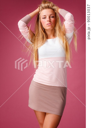 Fashion portrait of elegant young woman with curly blonde hair over pink background 90013037