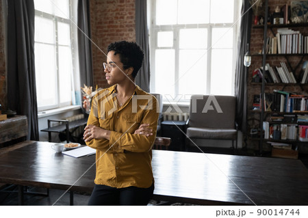 Serious African businesswoman pose in office staring aside looks thoughtful Serious African businesswoman pose in office staring aside looks thoughtful 90014744