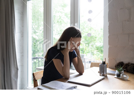 Shocked tired student girl holding head, touching temples 90015106