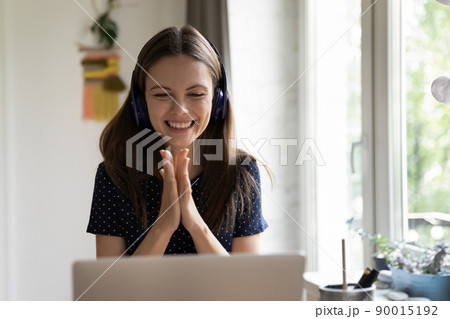 Happy cheerful laptop user girl in wireless headphones enjoying luck Happy cheerful laptop user girl in wireless headphones enjoying luck 90015192