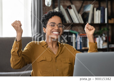 African woman sit at desk with laptop celebrate great news 90015382