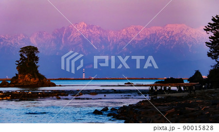 富山県高岡市　雨晴海岸から富山湾越しの　夕陽に染まる剣立山連峰の絶景 90015828