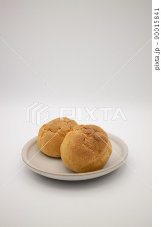 白い陶器皿の上のシュークリーム2個 縦 Two cream puffs on a plate 白い陶器皿の上のシュークリーム2個 縦 Two cream puffs on a plate 90015841