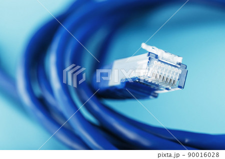 A coil of an Internet network cable for data transmission on a blue background 90016028