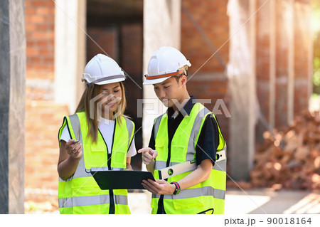Team of construction engineers discussing the design of construction together Team of construction engineers discussing the design of construction together 90018164