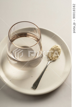 Protein powder and a spoon with glass of water. Food supplements Protein powder and a spoon with glass of water. Food supplements 90018382