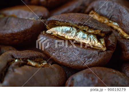 Roasted coffee beans scattered in random order on a dark background 90019279