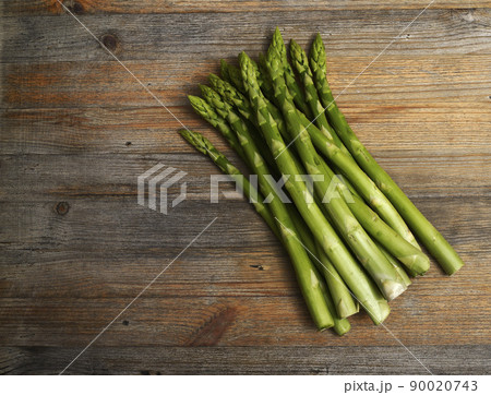 a bundle of asparagus on a wooden background with room for text 90020743