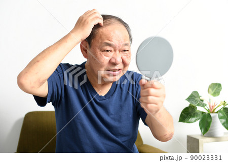 鏡を見ながら薄毛に悩む中高年の男性 90023331