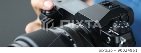 Woman holding modern camera for photos, close-up Woman holding modern camera for photos, close-up 90024961