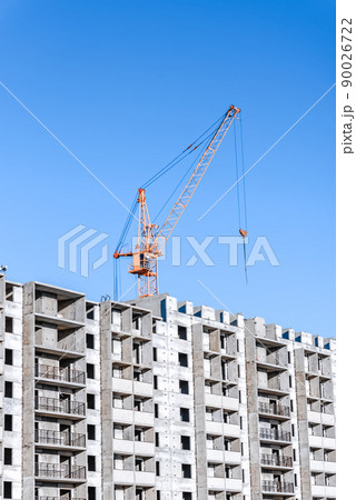 Industrial landscape with silhouettes of cranes on the blue sky background Industrial landscape with silhouettes of cranes on the blue sky background 90026722
