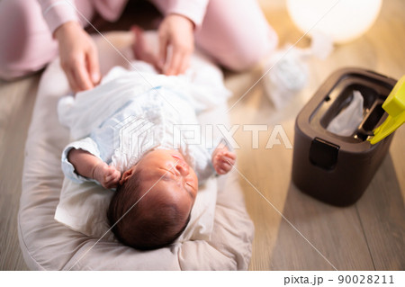 夜間の赤ちゃんのおむつ交換 泣く おむつ替え 紙おむつ 生後1ヶ月の写真素材