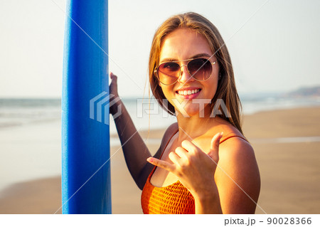 beautiful surfer girl finger hand symbols making a call phone me or aloha greetings surfers.girl surfer on the beach with surfboard beautiful surfer girl finger hand symbols making a call phone me or aloha greetings surfers.girl surfer on the beach with surfboard 90028366