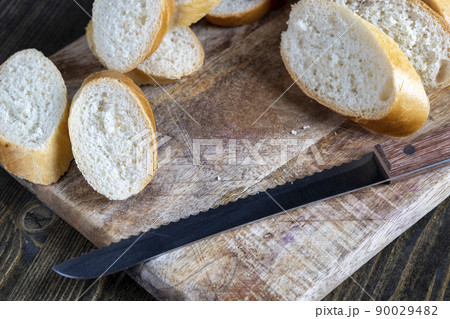 wheat baguette cut into pieces on a cutting board 90029482