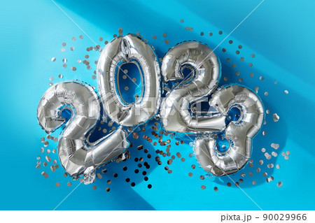 Silver numbers 2023 new year balloons in sunlight blue background 90029966
