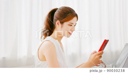 woman uses laptop and phone woman uses laptop and phone 90030238