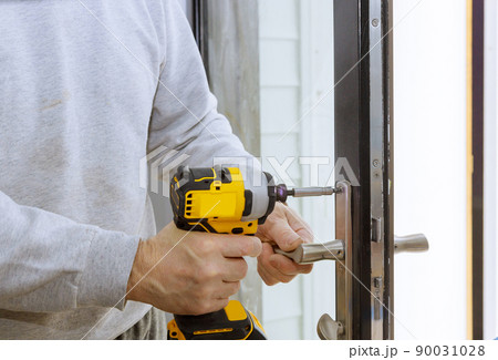 Builder in installing a door lock the door of a new house 90031028