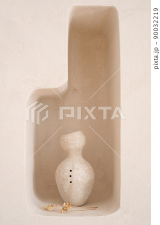 Ceramic handmade vase in a minimalist style on a shelf in the wall. 90032219