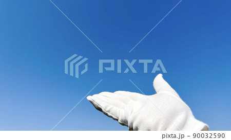 青空に白手袋をした手_左スペース 90032590