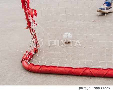 Floorball goal. Children playing outdoor in spring. Floor hockey players goalkeeper running with ball and sticks 90034225