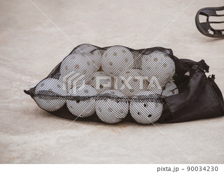 Floorball balls in bag. Children playing outdoor in spring. Floor hockey players goalkeeper running with ball and sticks 90034230