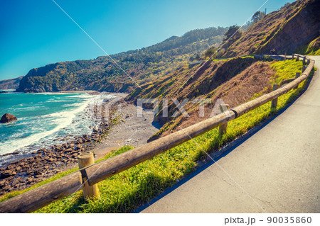 Mountain road along the sea on a sunny day 90035860