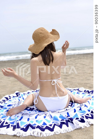 九十九里の海岸でポーズをとる白いビキニを着た若い女性の後ろ姿 90036399