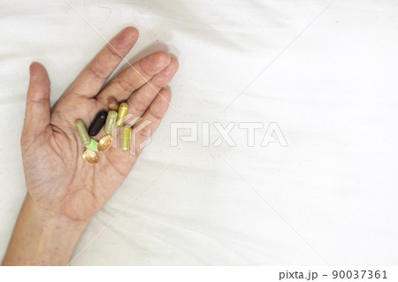 Close up supplement food in hand. Health care concept on white background. 90037361