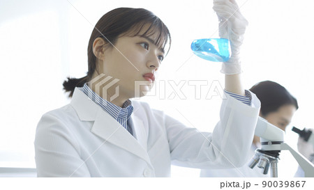 フラスコを見つめる白衣の女性 研究 実験 90039867