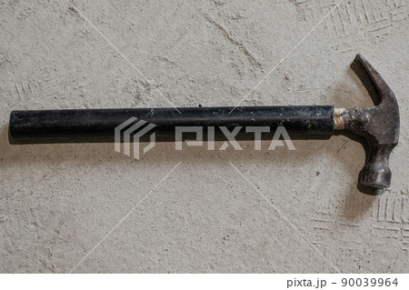 Hammer construction tool lies on the concrete floor. 90039964